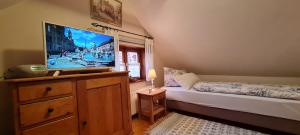 a bedroom with a television on a dresser with a bed at Ferienhaus am Marienkloster in Quedlinburg