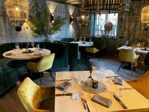 ein Restaurant mit Holztischen, Stühlen und Kronleuchtern in der Unterkunft Dahoam by Sarina - Village Appartements in Zell am See