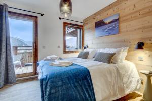 a bedroom with a large bed and a balcony at Echo du Pleney A204 in Morzine