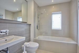 a bathroom with a tub and a toilet and a sink at 5 The Sands in Polzeath +28 photos