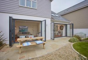 a patio with a bench in front of a house at 5 The Sands in Polzeath