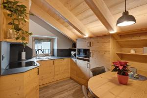 a kitchen with wooden cabinets and a wooden table at Gemma Rosina's Home in Livigno