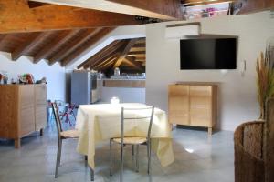 una sala da pranzo con tavolo, sedie e TV di L’attico del capitano: loft con terazza sul mare a Marina di Caronia