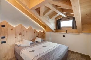 a bedroom with a large bed with a wooden ceiling at Gemma Rosina's Home in Livigno