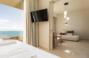 a bedroom with a bed and a tv and a couch at KALES SEA VIEW SUITES in Ierápetra +27 photos