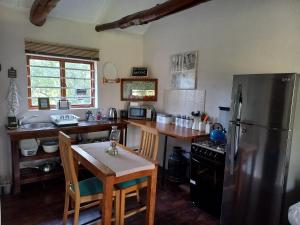 a kitchen with a stainless steel refrigerator and a table at Aloe Valley Retreat in Oudtshoorn