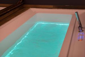 a bath tub with blue water in it at Tredici Boutique Rooms in Naples