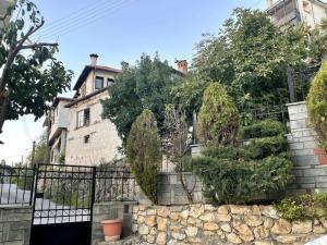 una pared de piedra con árboles y plantas en Belvedere garden en Kastoria