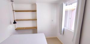 a white room with a window and a white bench at Residencial Viva Torres - Casas com 2 Dorms, Ar e Piscina Aquecida na Praia da Cal in Torres