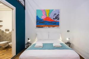 拿坡里的住宿－Tredici Boutique Rooms，卧室配有一张床,墙上挂有绘画作品