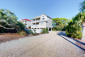a large white house with a gravel driveway at Serenity Now in St. George Island