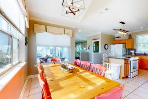 a kitchen and dining room with a wooden table and chairs at Serenity Now in St. George Island