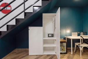 a room with a staircase with a white closet under the stairs at Tredici Boutique Rooms in Naples