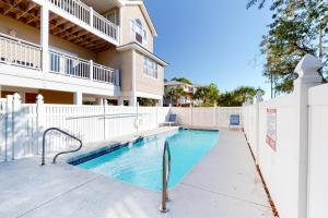 a swimming pool in front of a building at Serenity Now in St. George Island