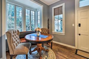 a dining room with a table and chairs and windows at Cozy Eureka Springs Cottage, Walk to Dtwn! in Eureka Springs