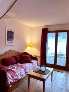 1 dormitorio con 1 cama con mesa y ventana en Chalet VARS 8 à 10 personnes, proche des pistes, en Vars