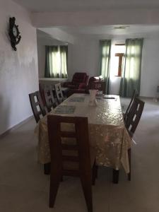 a dining room table with chairs and a table cloth at tina house in Bel Ombre