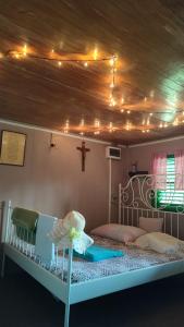 ein Schlafzimmer mit einem Bett mit einem Kreuz an der Decke in der Unterkunft Robinzonski smjestaj BB-HILL in Zabok