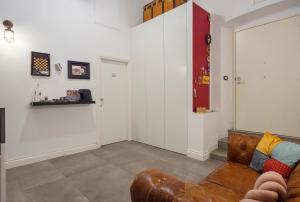 a living room with a brown couch and a wall at Tredici Boutique Rooms in Naples
