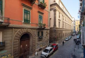 a street with cars parked next to a building at Tredici Boutique Rooms in Naples