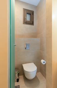 a small bathroom with a toilet and a mirror at KALES SEA VIEW SUITES in Ierápetra