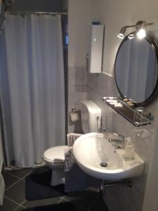 a bathroom with a sink and a toilet and a mirror at Pension Grafl in Schattendorf