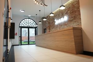 a lobby with a brick wall and a reception desk at HALO Apartament 07 in Wrocław
