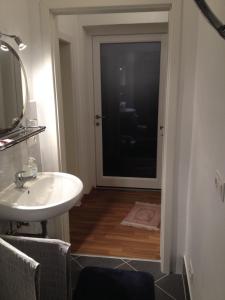 ein Badezimmer mit einem Waschbecken, einem Spiegel und einer Tür in der Unterkunft Pension Grafl in Schattendorf
