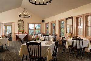 a dining room with white tables and chairs and windows at Chesterfield Inn in West Chesterfield