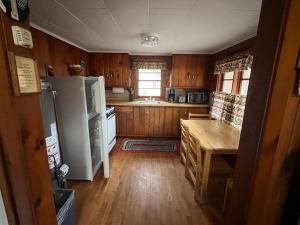 a kitchen with a refrigerator and a table in it at Red Tree Resort LLC in Phillips