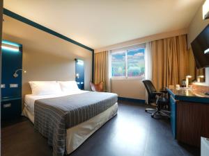 A bed or beds in a room at La Meridiana Bleisure Hotel