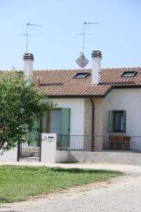 una casa con puertas verdes y una valla en Grillo Casa Vacanze en Tessera