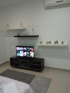 uma sala de estar com uma televisão de ecrã plano num suporte em Shaftsbury residence cyberjaya studio suites with free parking em Cyberjaya