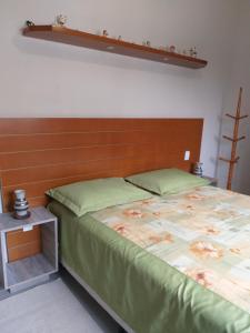 1 dormitorio con 1 cama con cabecero de madera en Recanto da Praia Paraíso, en Torres