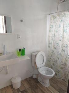 een badkamer met een toilet, een wastafel en een douchegordijn bij Recanto da Praia Paraíso in Torres +27 foto's
