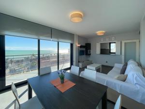 a living room with a couch and a table with chairs at Apartamentos la Volta Aguamarina in Peñíscola +56 photos