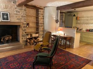 a living room with a table and chairs and a fireplace at Chez Katia in Semur-en-Auxois