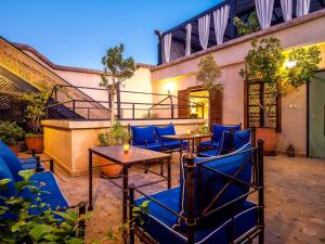 an outdoor patio with blue chairs and tables at Riad La Croix Berbere De Luxe in Marrakesh