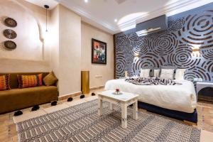 een hotelkamer met een bed en een bank bij Riad La Croix Berbere De Luxe in Marrakesh