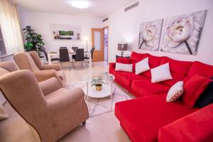 - un salon avec un canapé et des fauteuils rouges dans l'établissement Apartamento Romero Valencia, à Benicull