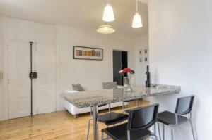 een keuken en eetkamer met een marmeren aanrecht en stoelen bij BmyGuest - Castelo Stylish Flat in Lissabon