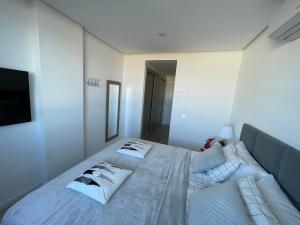 A bed or beds in a room at Ocean Garden Sunset Apartment - heated swimming pool Free WIFI