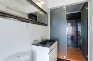 ein Bad mit einem Waschbecken und einem Spiegel in der Unterkunft BmyGuest - Castelo Stylish Flat in Lissabon