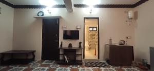 een kamer met een spiegel en een tv aan de muur bij Estancia Tranquila's Casa de la Abuela in Pondicherry
