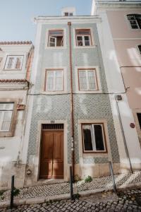 een hoog gebouw met een houten deur erop bij Romantic Blue in Lissabon