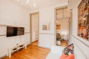 een woonkamer met een witte bank en een tv bij Romantic Blue in Lissabon