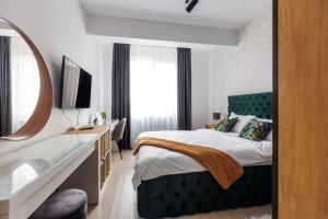 a bedroom with a bed and a sink and a mirror at Touchdown Apartment near Bucharest Airport in Otopeni