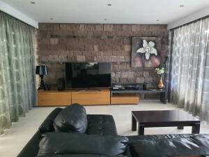 un soggiorno con divano e TV a schermo piatto di Exclusive Villa in Bahia del Duque ad Adeje