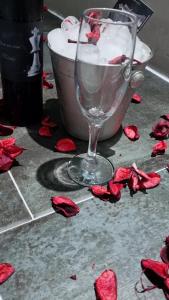 un bicchiere di vino seduto per terra con rose rosse sul pavimento di Checkmate a Tešanj