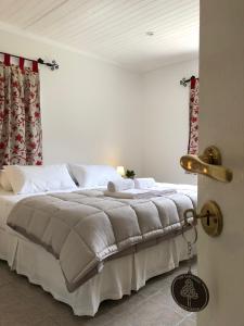 a bedroom with a large bed with white sheets at HOSPEDAR CALAFATE - Los Lupinos in El Calafate